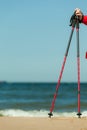 Nordic walking. Red sticks on the sandy beach Royalty Free Stock Photo