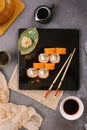 Nori Maki Philadelphia Sushi Rolls Set with Raw Salmon and Cream Cheese on Black Stone Table Background with Place for Text.