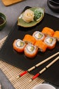 Nori Maki Philadelphia Sushi Rolls Set with Raw Salmon and Cream Cheese on Black Stone Table Background with Place for Text. Royalty Free Stock Photo
