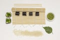 Nori sushi rolls on bamboo mat. Wasabi in bowl, rice and chopsticks on table Royalty Free Stock Photo