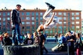 Norilsk, Russia - August, 28, 2016: Young teenager jumps and does somersaults. Parkour on the street. Royalty Free Stock Photo