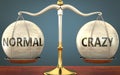 Normal and crazy staying in balance - pictured as a metal scale with weights and labels normal and crazy to symbolize balance and