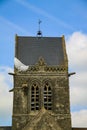 Normandy, France; 4 June 2014: The soldier landed on the steeple of the church of Sainte Mere Eglise