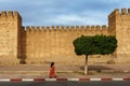 Morocco. Taroudant. A woman walking front of the city walls