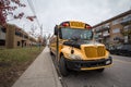 North American Yellow School Bus parked on a street, waiting for students with cars passing by with information in French, accordi Royalty Free Stock Photo