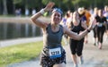 Women waving at camera while running 5K race around Belmont Lake