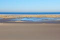 Beach walk of two people on the endless wide, sandy beach of  Norderney Island in February Royalty Free Stock Photo