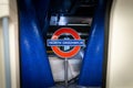 North Greenwich Underground Station, London Platform TFL sign red and blue taken looking out from train carriage through closing d Royalty Free Stock Photo