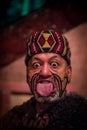 NORTH ISLAND, NEW ZEALAND- MAY 17, 2017: Close up of a Maori man sticking out tongue with traditionally tatooed face in Royalty Free Stock Photo