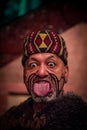 NORTH ISLAND, NEW ZEALAND- MAY 17, 2017: Close up of a Maori man sticking out tongue with traditionally tatooed face in Royalty Free Stock Photo