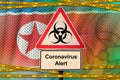 North Korea flag and Covid-19 biohazard symbol with quarantine orange tape. Coronavirus or 2019-nCov virus concept