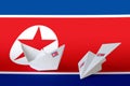 North Korea flag depicted on paper origami airplane and boat. Handmade arts concept