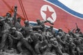 A North Korean flag and several bronze statues are part of the Socialist Revolution Monument, Pyongyang, North Korea
