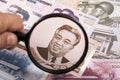 North Koreans money in a magnifying glass