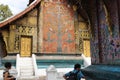 North Laos: Tourist visiting the Wat Xieng Thong temple in Luang Brabang City