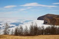 The north of Olkhon Island in spring. Beautiful view of the mountains, larch forest, ice floes in Lake Baikal