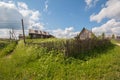 North Russian village Isady. Summer day, Emca river, old cottages on the shore, old wooden bridge. Abandoned building. Royalty Free Stock Photo