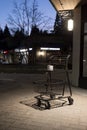 NORTH VANCOUVER, BC, CANADA - MAR 19, 2020: A shopping cart with a single roll of toilet paper sits on a sidewalk during