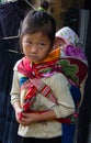 Vietnamese child carries little brother on her back