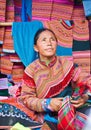 North Vietnamese woman in colorful native clothing sells similar