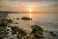 Golden hour sunset at Colwyn bay, North Wales. Warm sky and gentle waves along a rocky coastline Royalty Free Stock Photo