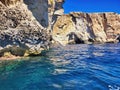 Northern coast grottos and rocks seen by boat. Sea cliffs. Close-up of a cave cliff in the sea. Beautiful landscape with mountains Royalty Free Stock Photo