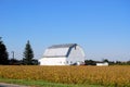 A white barn looking very clean under a clear blue sky.