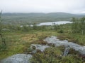Northern landscape in Swedish Lapland with granite rock, birch bush, green hills and Tarra river at Padjelantaleden Royalty Free Stock Photo