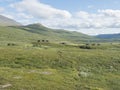 Northern landscape, tundra in Swedish Lapland with wooden cottages of STF Duottar tourist hut, blue artic river and lake