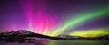Northern Light colorful dance in sky, phenomenon Aurora Borealis above forested snowy mountains Royalty Free Stock Photo