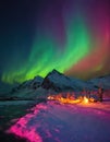 Northern Light colorful dance in sky, phenomenon Aurora Borealis over houses and snowy mountains Royalty Free Stock Photo