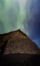Northern Lights above Icelandic landscape with basalt rocks