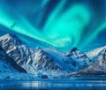 Northern lights above snowy mountains, frozen sea coast Royalty Free Stock Photo