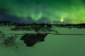 Northern lights above a water stream in a winter landscape. Royalty Free Stock Photo