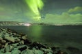 Northern lights, aurora borealis, above a fjord surrounded by a Royalty Free Stock Photo