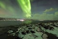 Northern lights, aurora borealis, above a fjord surrounded by a Royalty Free Stock Photo