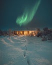 Northern Lights and Aurora Borealis over Winter landscape with wooden house under a beautiful starry sky and in Iceland. Royalty Free Stock Photo