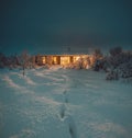 Northern Lights and Aurora Borealis over Winter landscape with wooden house under a beautiful starry sky and in Iceland. Royalty Free Stock Photo