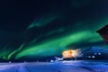 Northern lights in the mountains house of Svalbard, Longyearbyen city, Spitsbergen, Norway wallpaper Royalty Free Stock Photo
