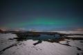 Northern lights reflecting in a pond on the shore of Iceland