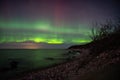 Northern Lights shimmering across the night sky above a shoreline Royalty Free Stock Photo