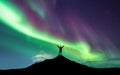 Northern lights and silhouette of man with raised up arms