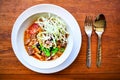 Northern Thai noodle curry soup with spoon and fork on wood table background Royalty Free Stock Photo