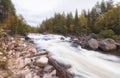 Northern turbulent river beyond the Arctic Circle. Stream on the threshold of Kolva or Kolvitsi in autumn with a long exposure