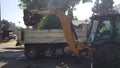 A CASE 590 Super N Backhoe Loader digs a trench at a construction site, lifting asphalt pieces