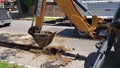 A CASE 590 Super N Backhoe Loader digs a trench with a worker in a construction vest and hardhat