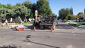 Backhoe starting a trench through asphalt and roadway on a Los Angeles street