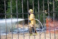 A firefighter uses a hose to put out a brush fire on a vacant lot in Northridge.