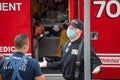 A LAFD firefighter gives a shrug gesture as Los Angeles paramedics respond to a medical call