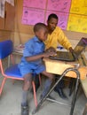 Teacher teaching primary schoolboy a computer. Royalty Free Stock Photo